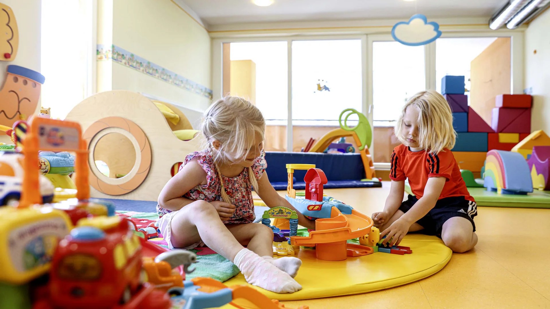 Children playing with colorful toys in bright playroom