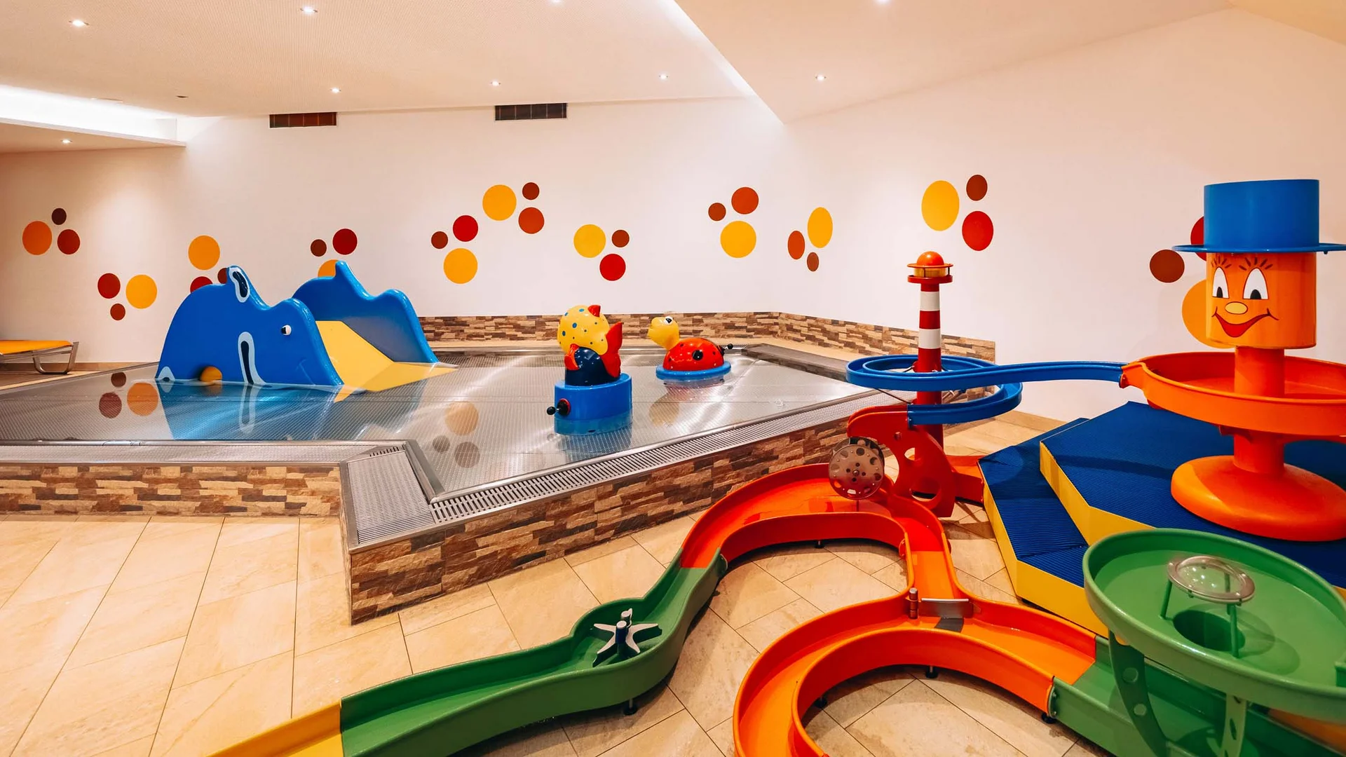 Buntes Indoor-Kinderbecken mit Rutschen und Wasserspielzeug