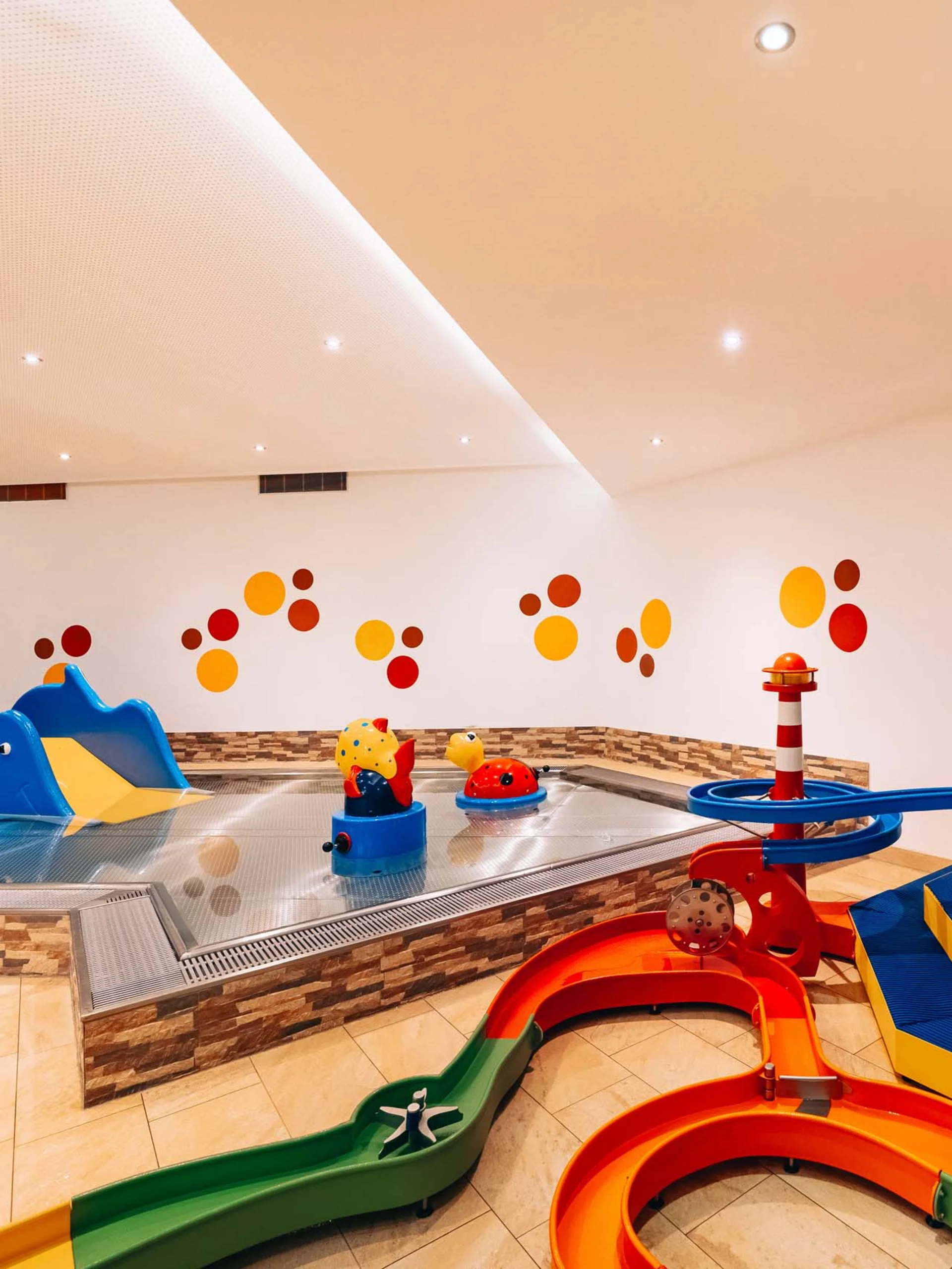 Buntes Indoor-Kinderbecken mit Rutschen und Wasserspielzeug