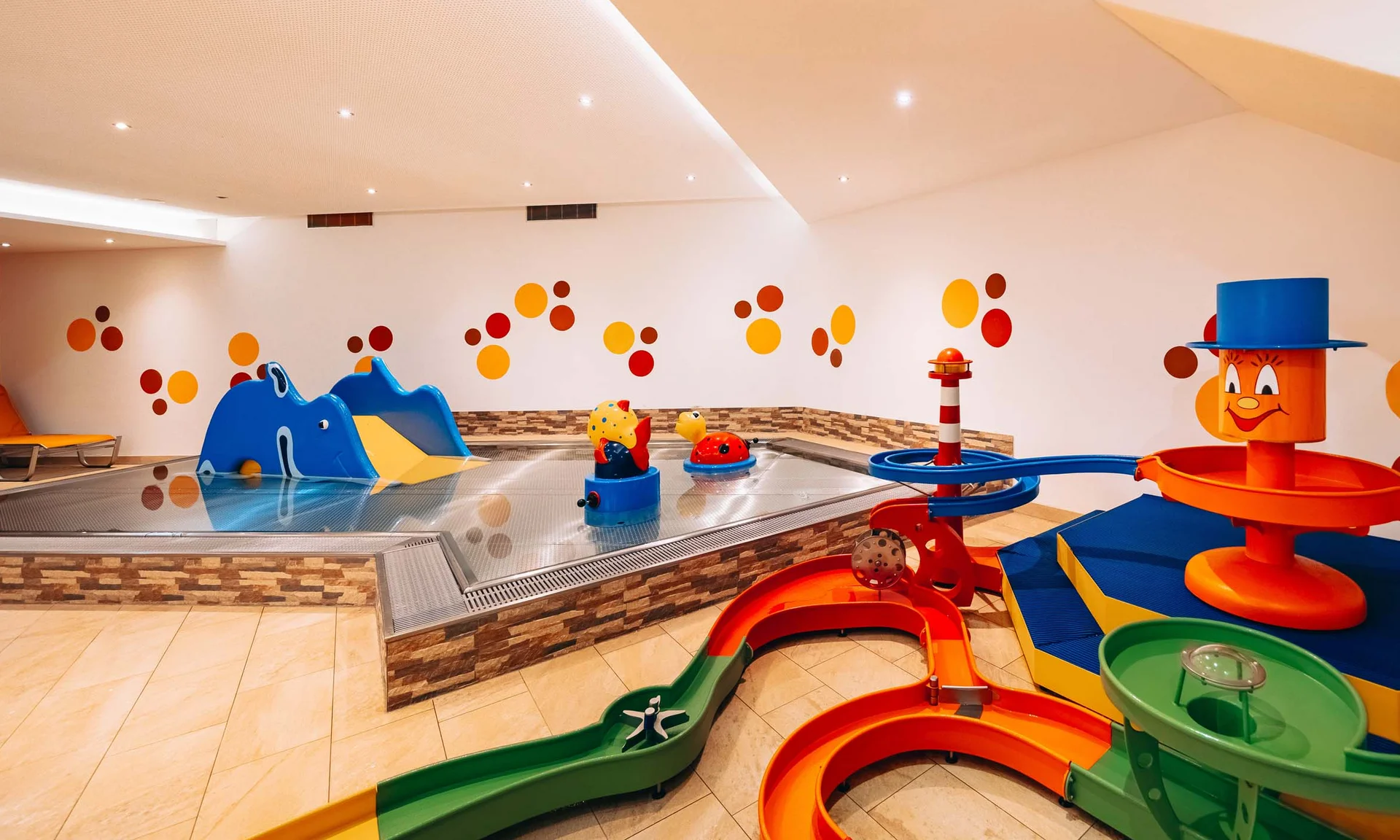 Buntes Indoor-Kinderbecken mit Rutschen und Wasserspielzeug