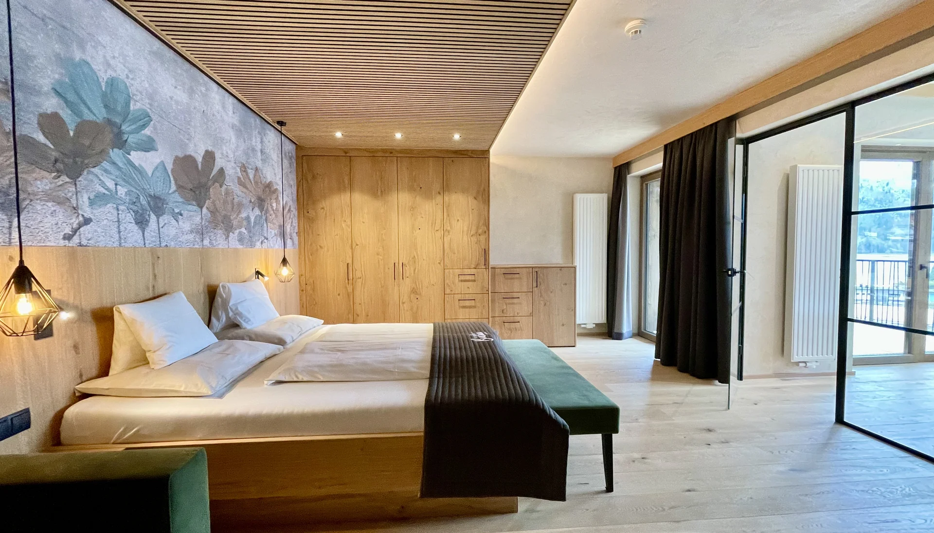 Modernes Schlafzimmer mit Holzmöbeln, großem Bett und Zugang zum Balkon
