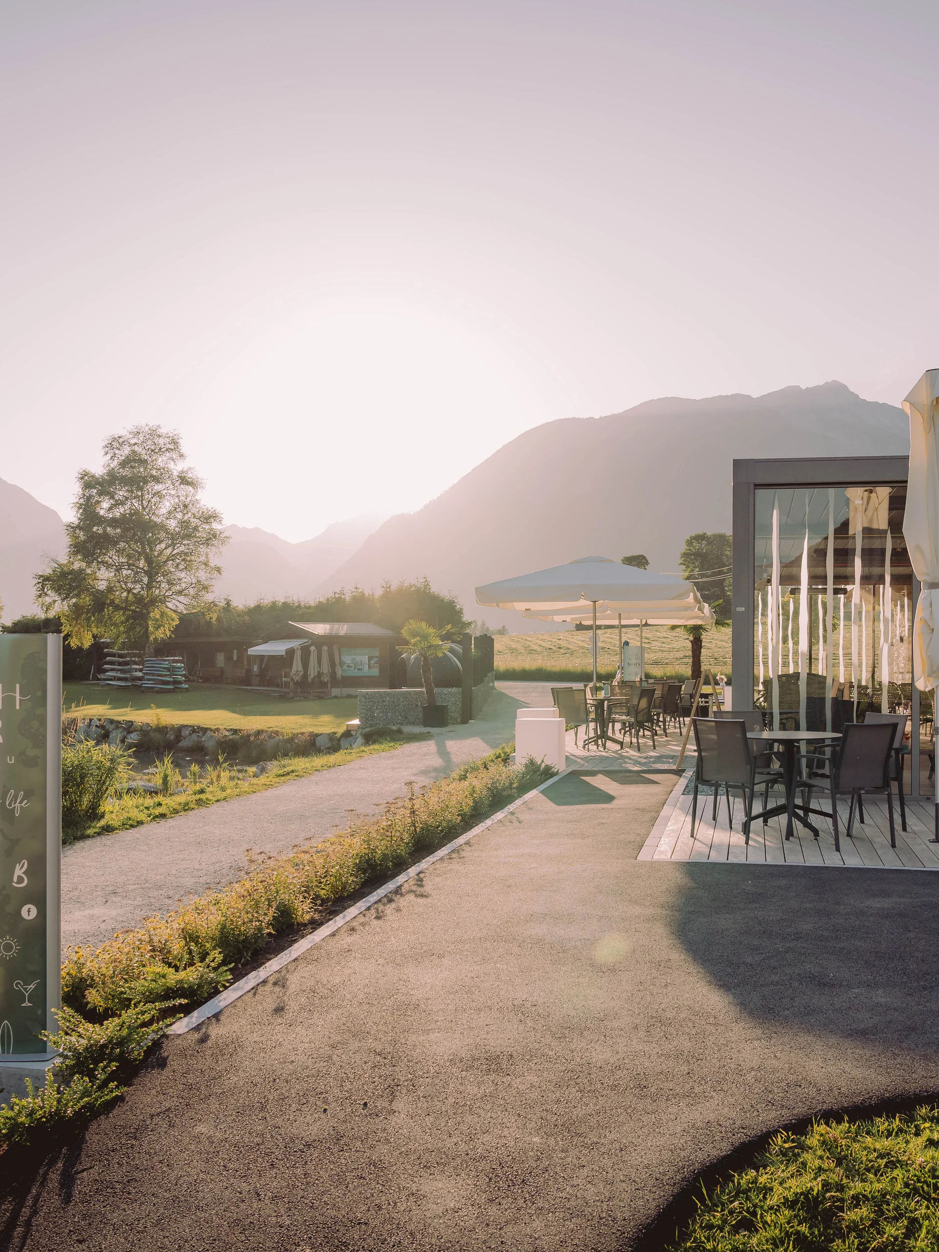 Außenbereich einer Beach Bar mit Bergblick bei Sonnenuntergang
