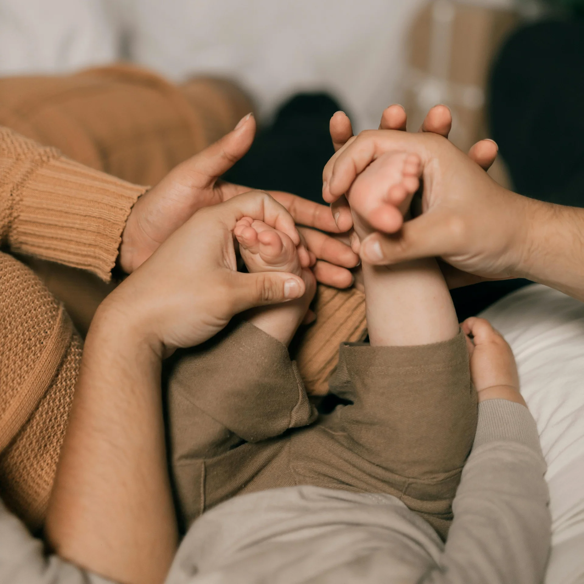 Eltern halten und massieren die Füße eines Babys