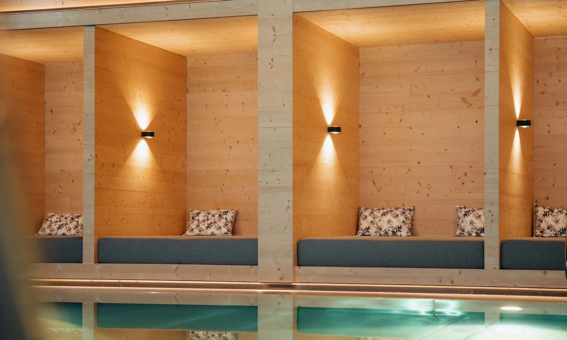 Holzvertäfelte Lounge mit gepolsterten Bänken und sanfter Wandbeleuchtung
