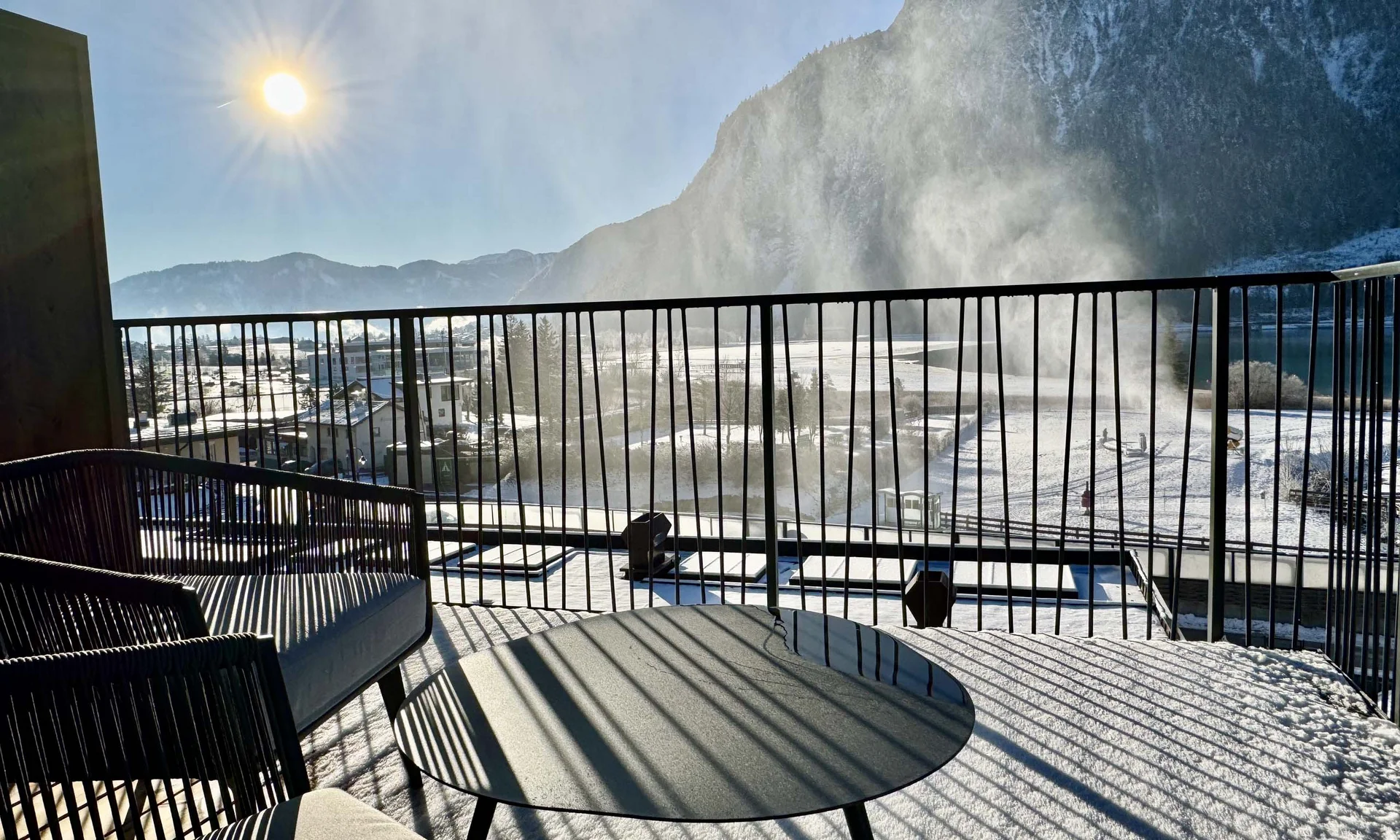 Sonniger verschneiter Balkon mit Bergblick und Nebel am Morgen