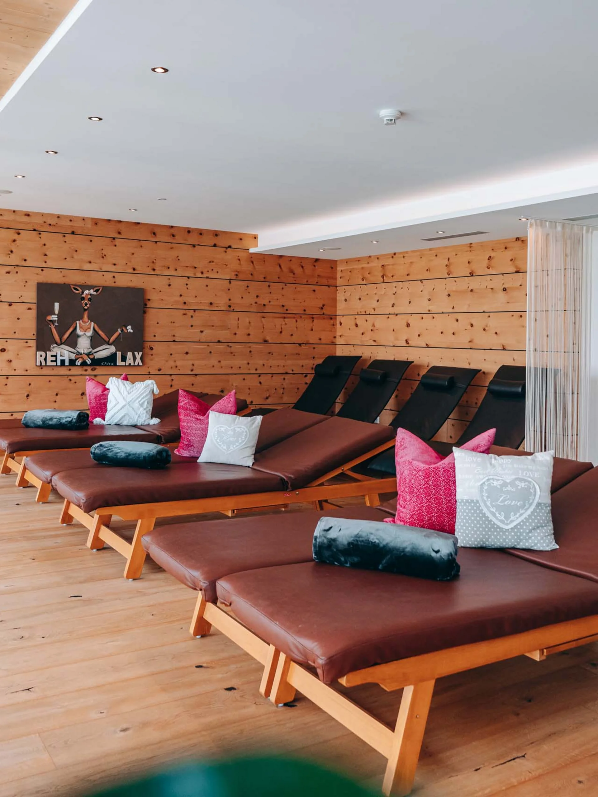 Ruheraum mit Liegen, Holzboden und Holzwänden in einer entspannten Atmosphäre