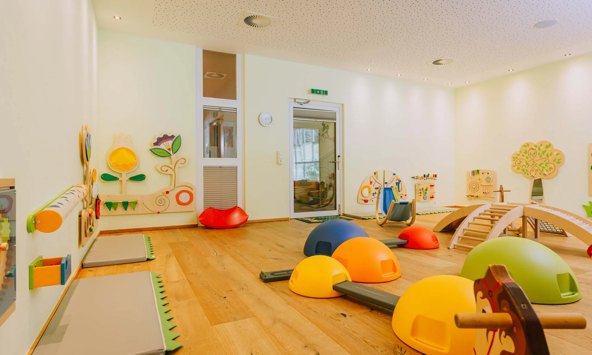 Children's playroom with colorful play equipment and wooden wall toys