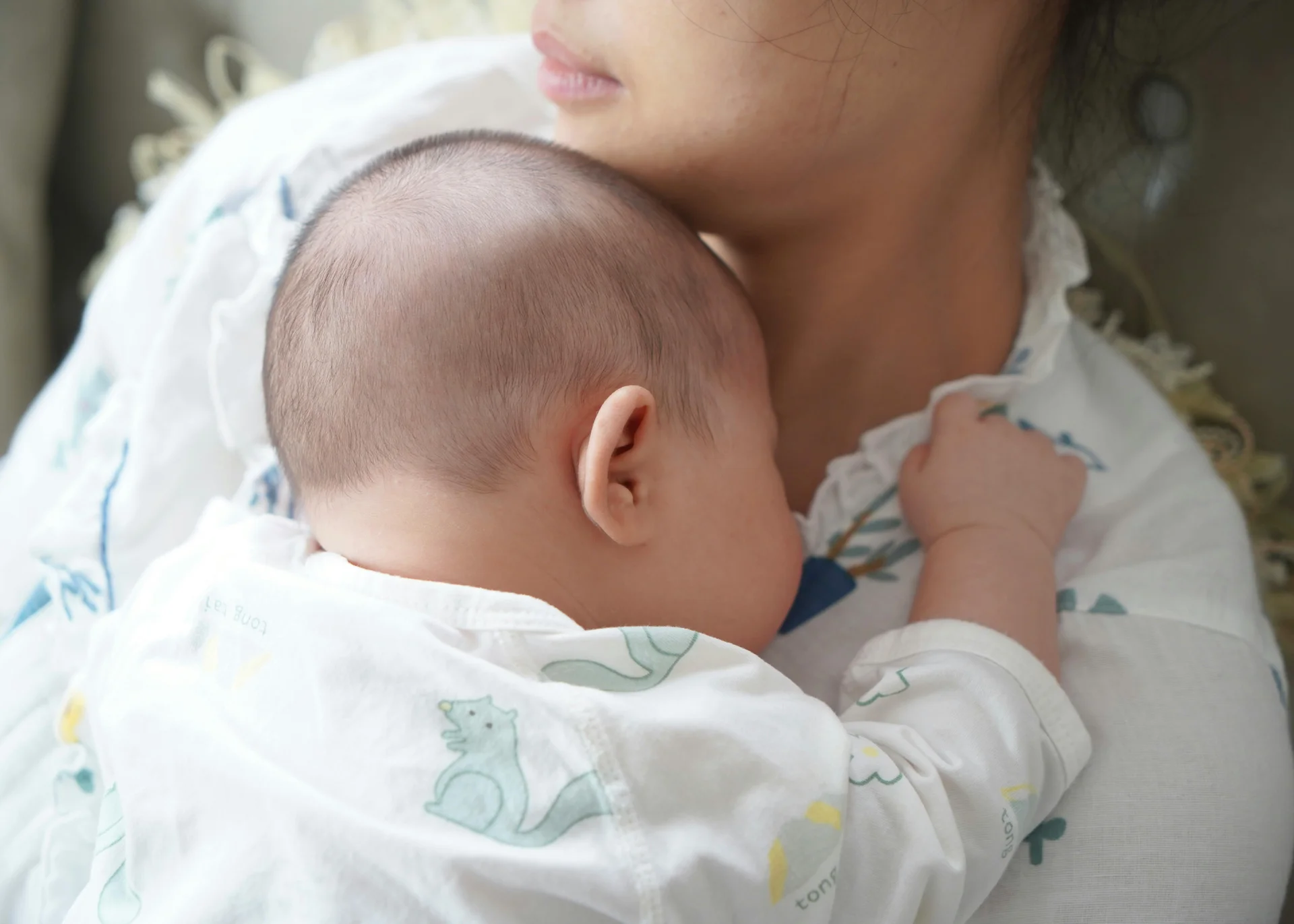 Baby sleeping on mother's shoulder
