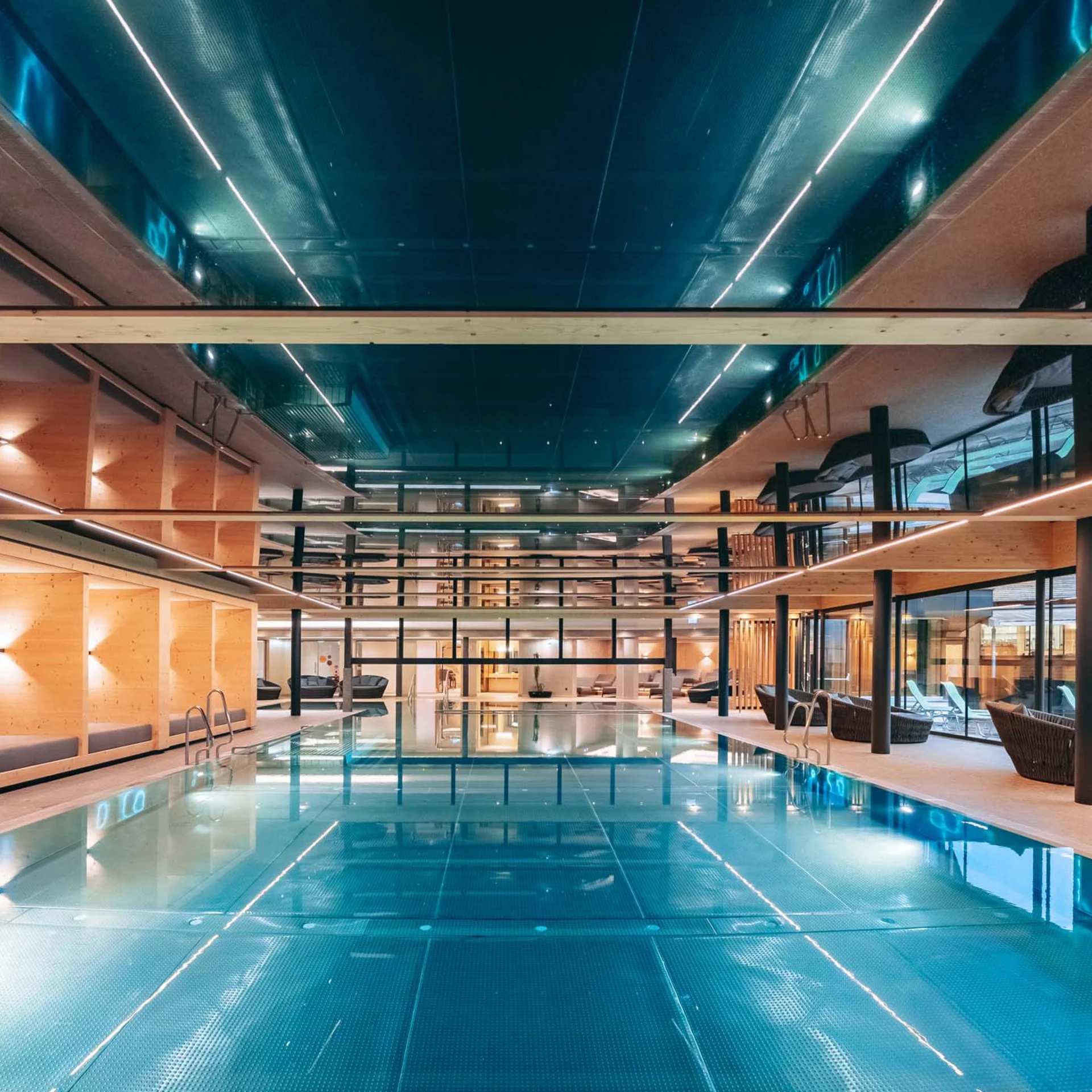 Moderner Innen-Schwimmbad mit Liegebereichen und Holzwänden