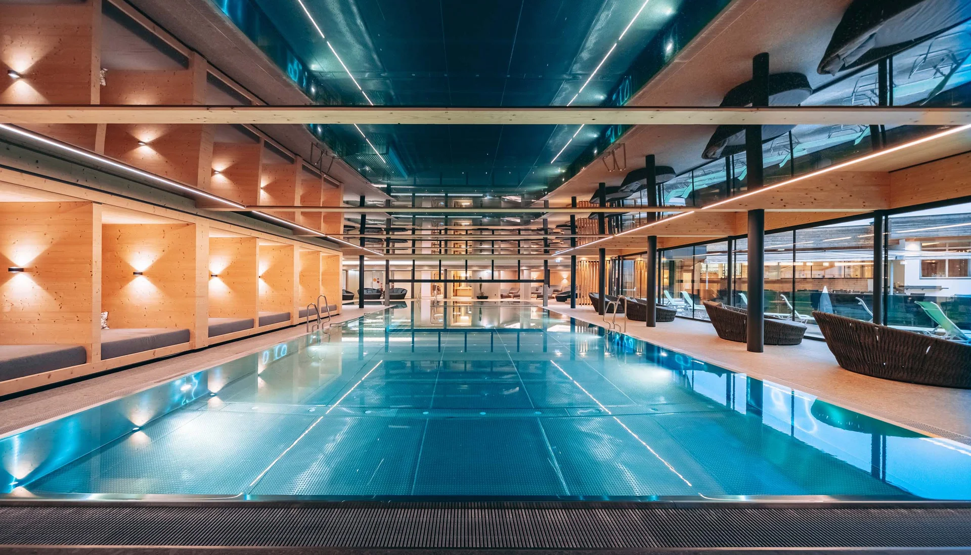 Moderner Innen-Schwimmbad mit Liegebereichen und Holzwänden