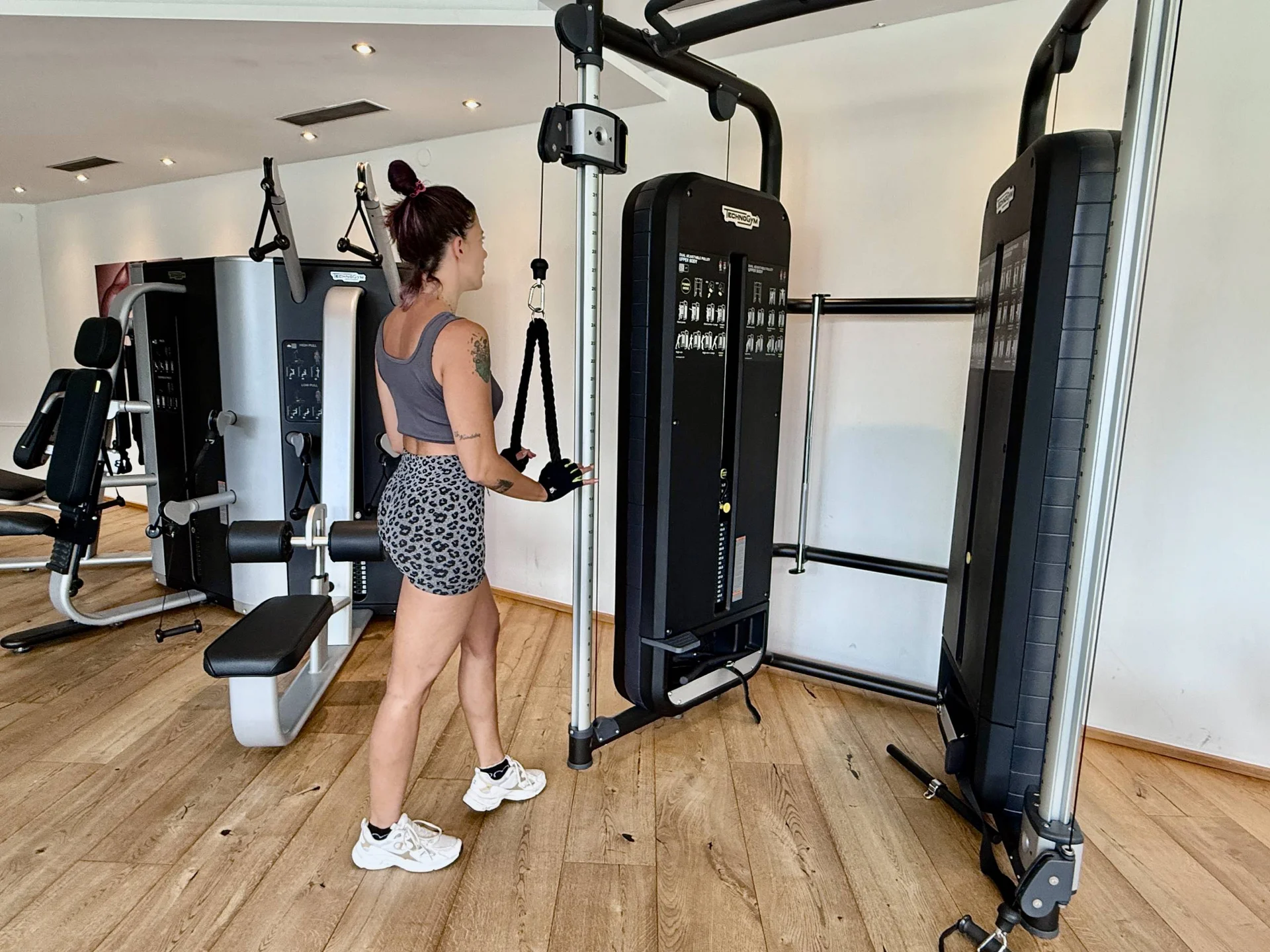Frau trainiert an Kabelzugmaschine im Fitnessstudio