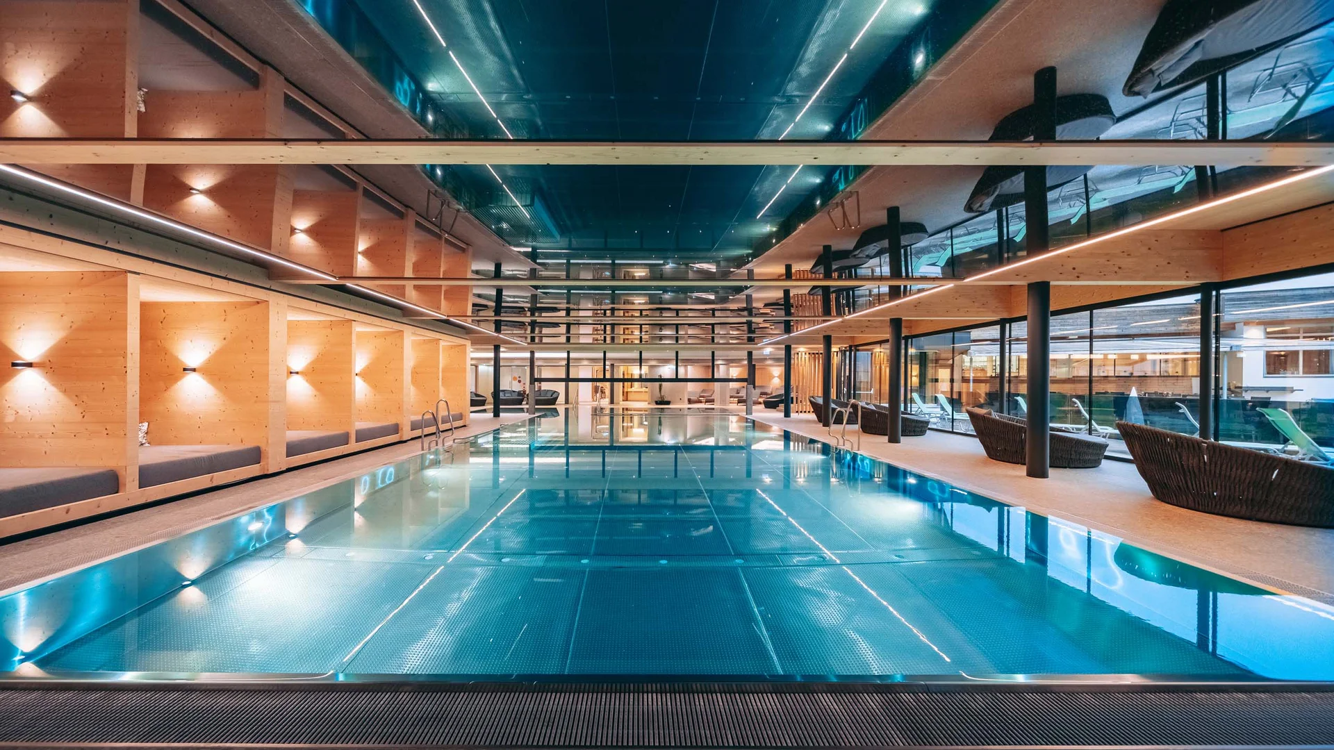 Moderner Innenpool mit Holzwänden und Liegestühlen