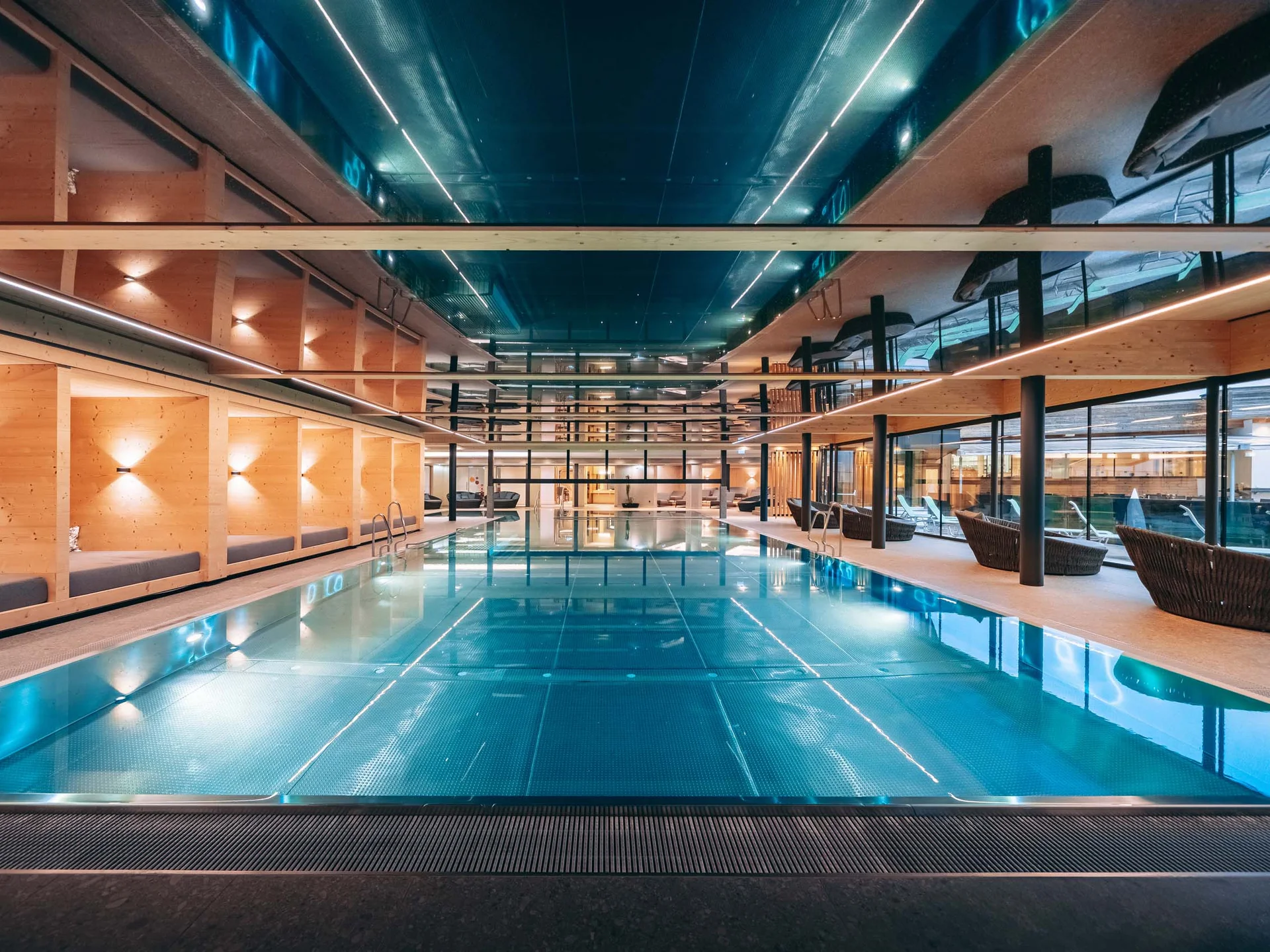Moderner Innenpool mit Holzwänden und Liegestühlen