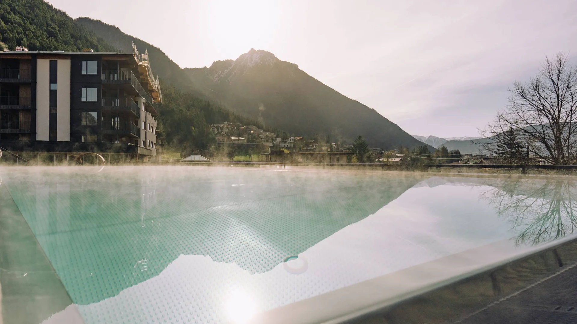 Dampfschwimmbecken mit Bergblick bei Sonnenuntergang