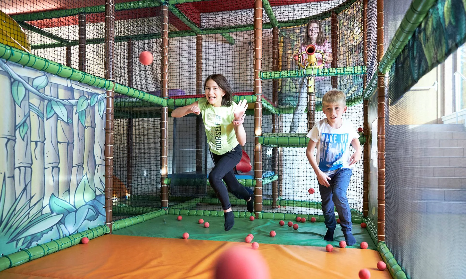 Kinder spielen in einer Indoor-Spielanlage mit roten Schaumstoffbällen