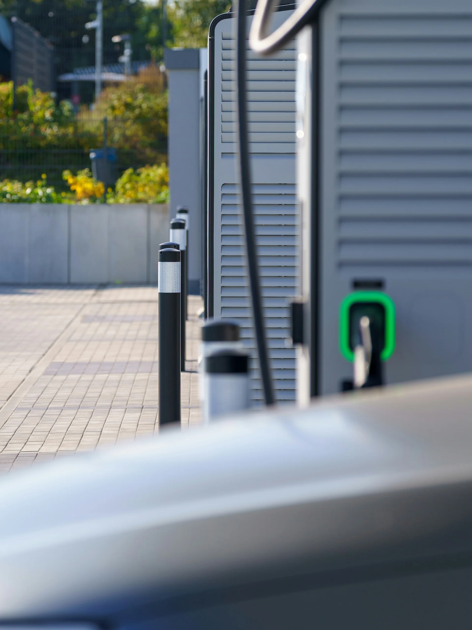 Urlaub im Familienresort in Österreich Ladestation mit grünem Anschluss neben einem geparkten Elektroauto