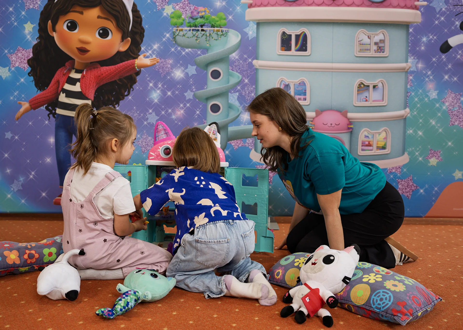 Three days full of phantasy, fun and shared happiness Woman and two girls playing with toys in front of colorful wall art
