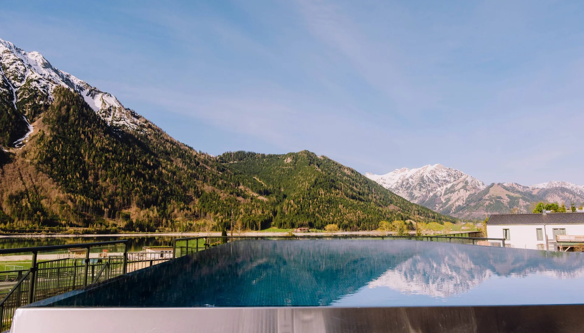 Infinity-Pool mit Bergblick und Spiegelung bei klarem Himmel