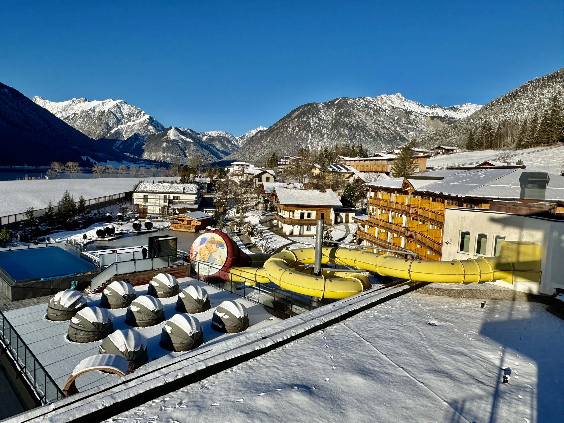 The family resort in Buchau for quality time in Tyrol Snow-covered resort with water slide and mountains in the background in winter