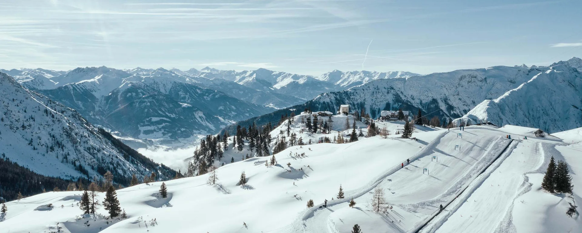 Verschneite Alpenlandschaft mit Skigebiet und klarem Himmel