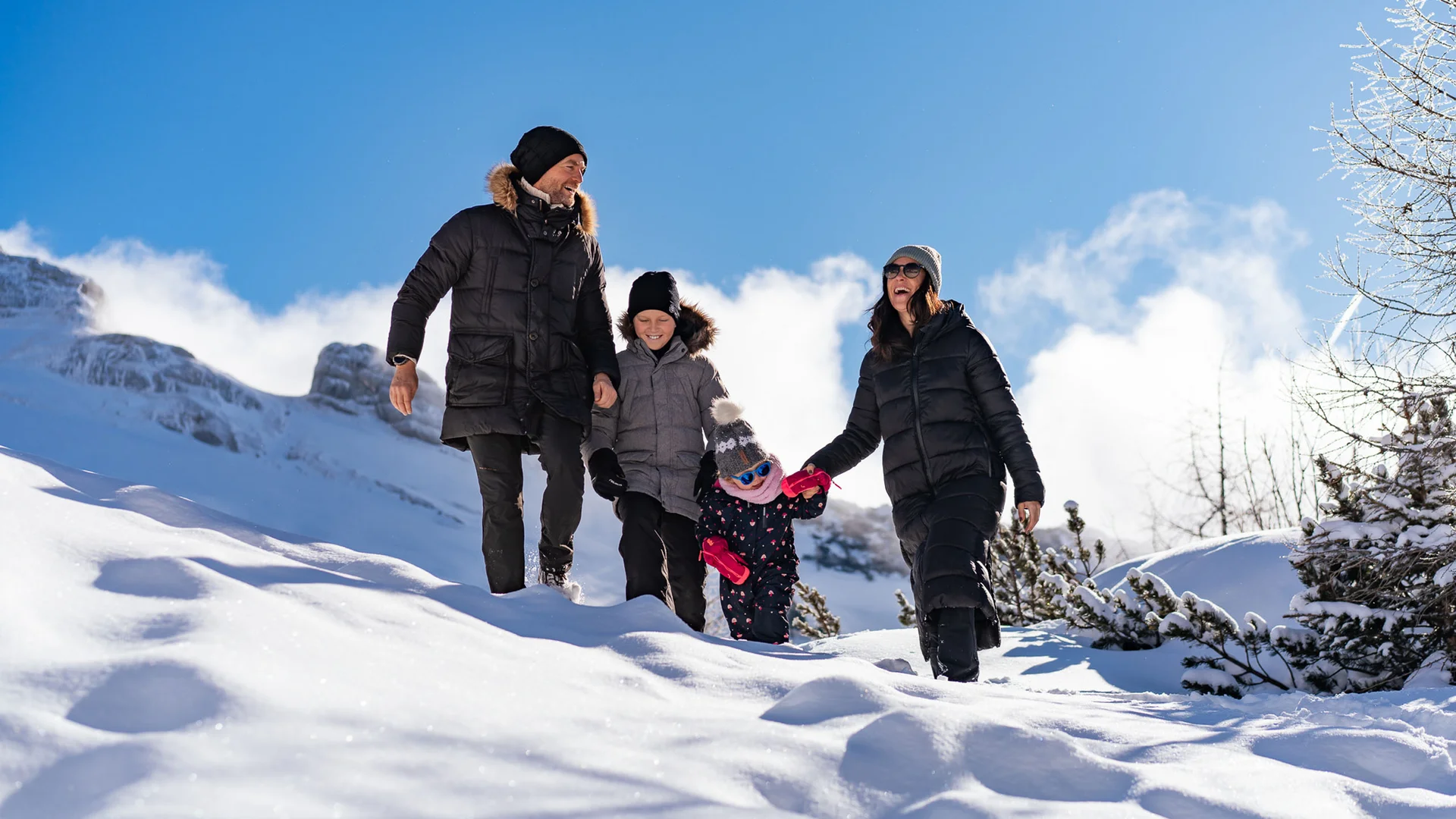 Familienzeit im Kinderhotel Buchau am Achensee Familie mit vier Personen wandert an sonnigem Wintertag im Schnee