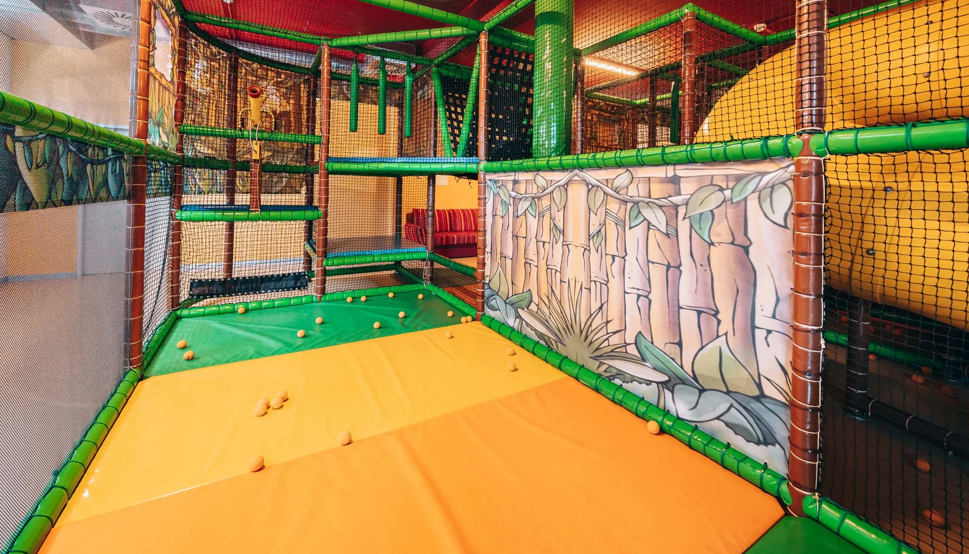 Interior of colorful indoor playground with climbing structures and soft mats