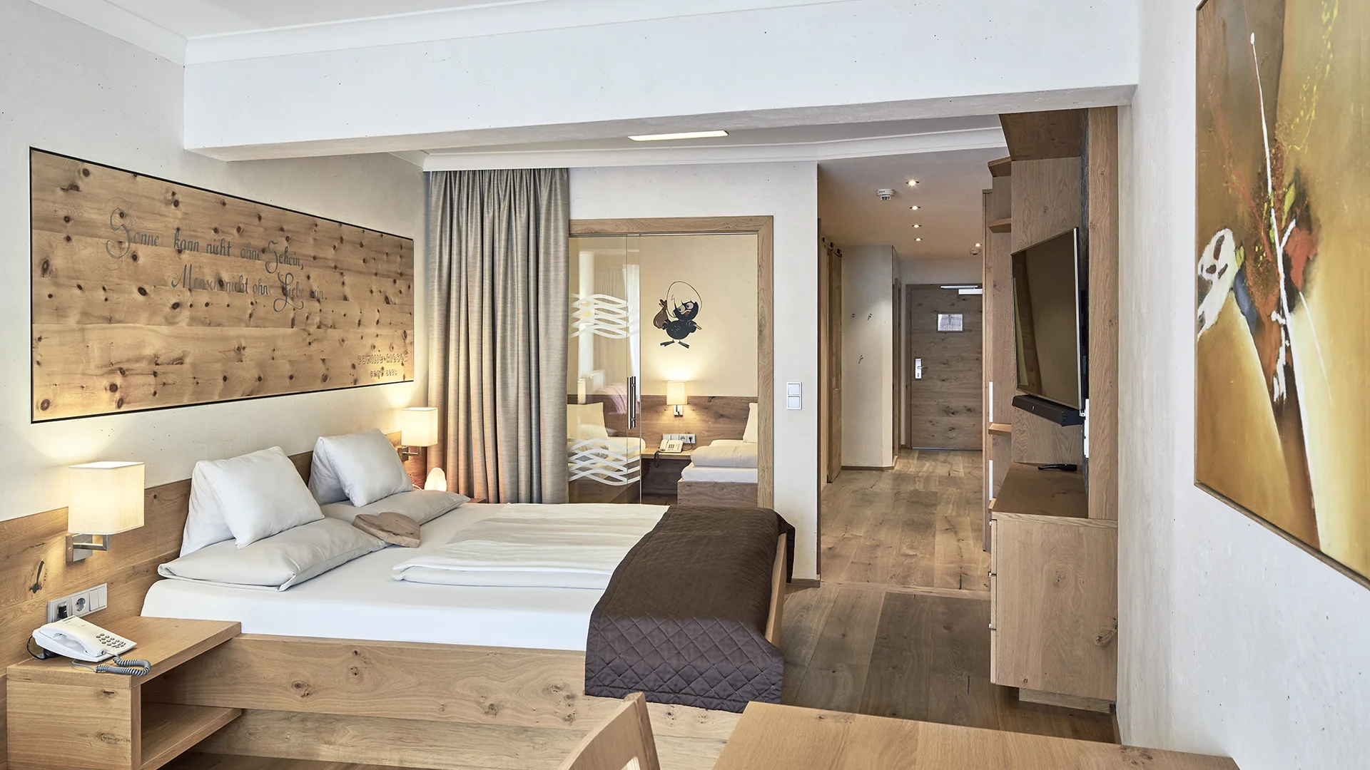 Modernes Hotelzimmer mit Holzmöbeln, Doppelbett und Flur zum Eingang