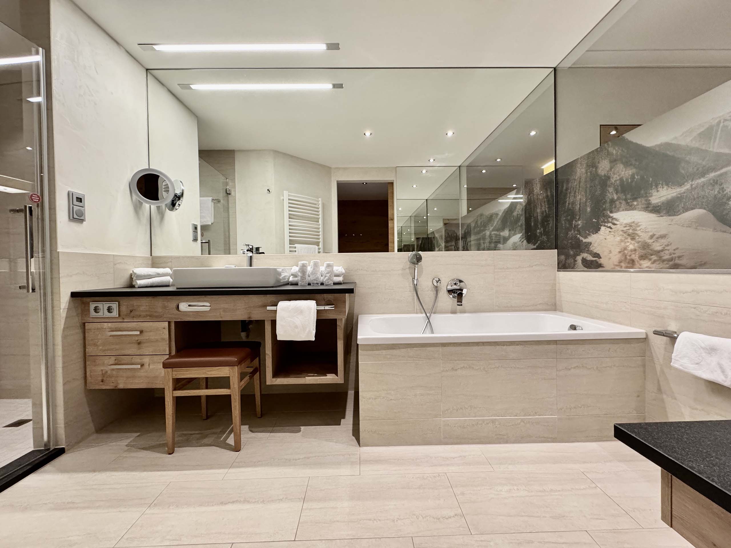 Modernes Badezimmer mit Badewanne, großem Spiegel und Waschtisch aus Holz